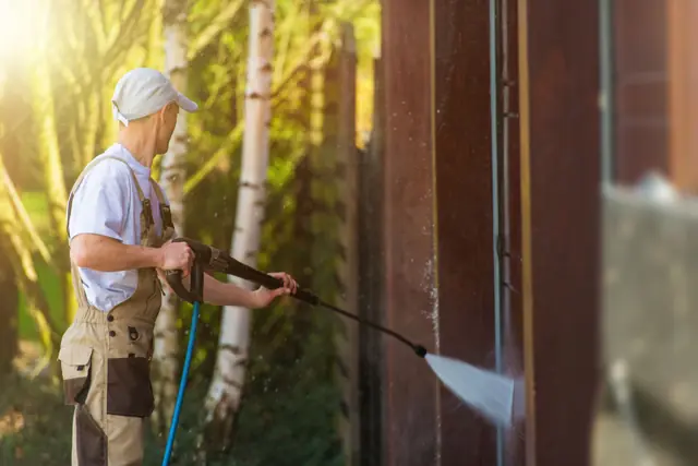 Technician pressure washing outdoors